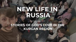 A group of people, including adults and children, sit around a long table with drinks. Text reads: "New Life in Russia: Stories of God's Love in the Kurgan Region.